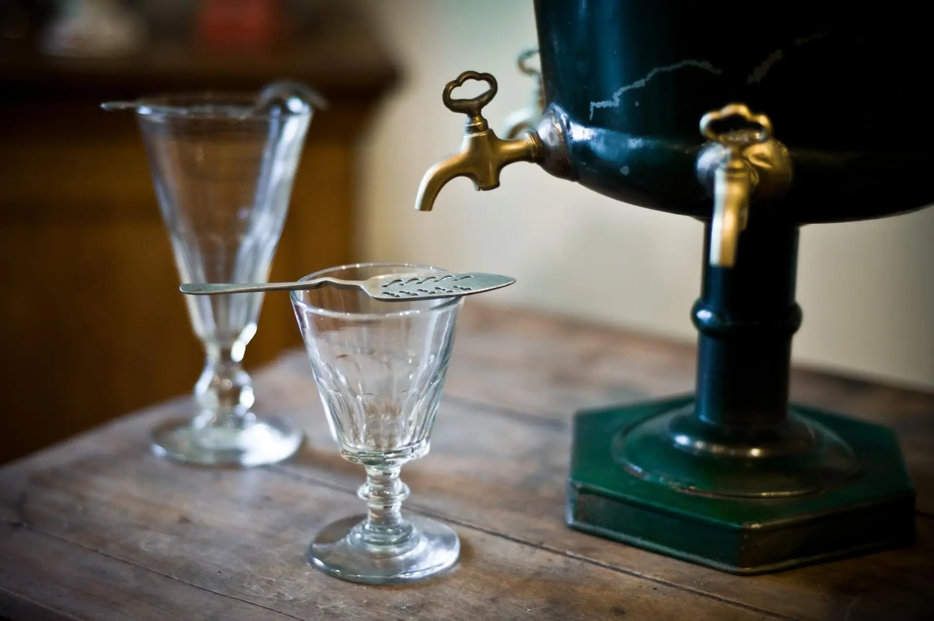 Fontaine à absinthe et verres sur une table en bois